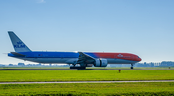 Amsterdam, The Netherlands - August 25, 2016: Boeing 777-300 of KLM with Olympic livery landing at Schiphol's Polderbaan. This plane is partly painted orange because of the Olympic Games in Rio de Janeiro in the summer of 2016. KLM - Koninklijke Luchtvaart Maatschappij N.V. (Royal Dutch Airlines) is the flag carrier airline of the Netherlands.
