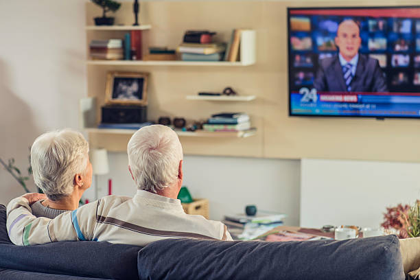 istock Rear view of unrecognizable senior couple looking television 595729480