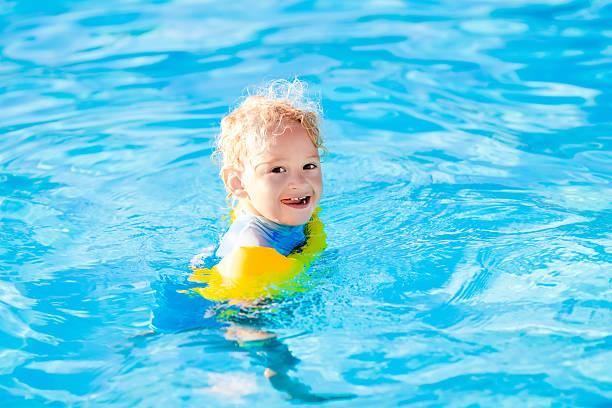 istock Little child in swimming pool 595730062
