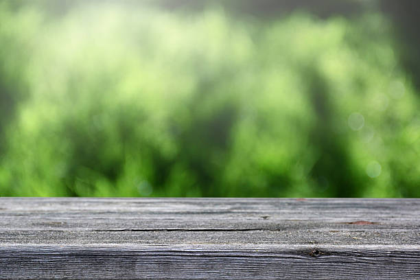 istock Soft blur wooden table and defocused green background. 595731702