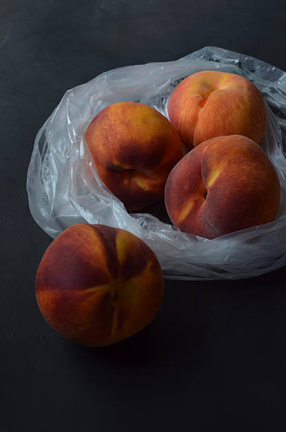 istock peaches in plastic grocery store bag 595732554