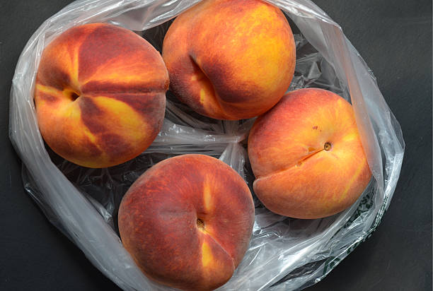 istock Fresh tree ripened peaches in plastic grocery store produce bag 595733094