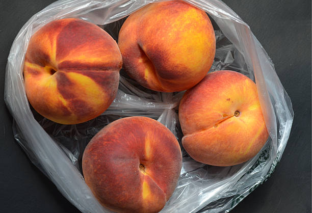 istock Fresh tree ripened peaches in plastic grocery store produce bag 595733258