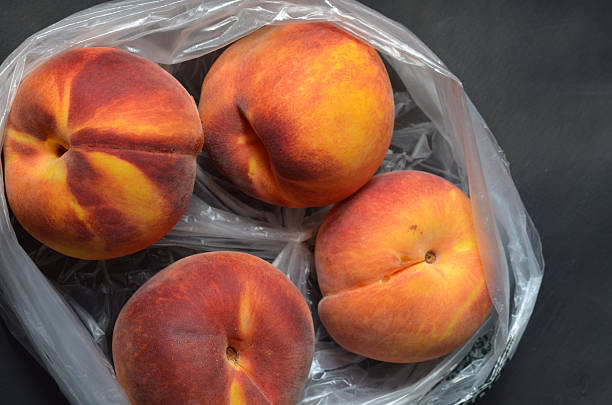 istock Fresh tree ripened peaches in plastic grocery store produce bag 595733368