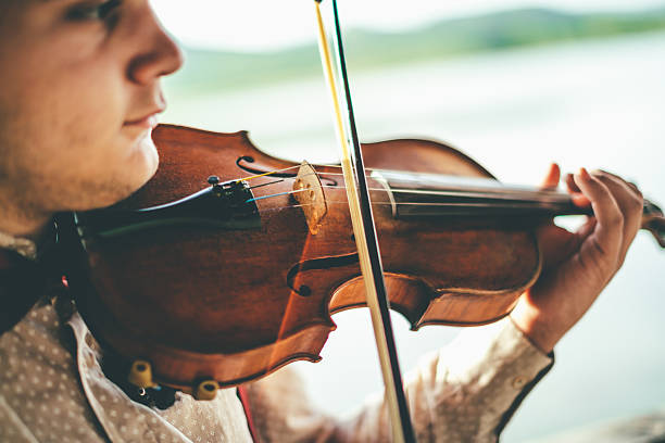 istock Playing violin by the lake 595733868