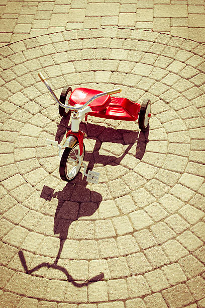 istock Red Tricycle with Shadow on Sunny Stone Patio 595734908
