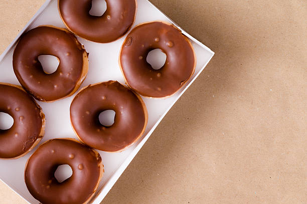 Top down view of chocolate and cream donuts in box stock photo
