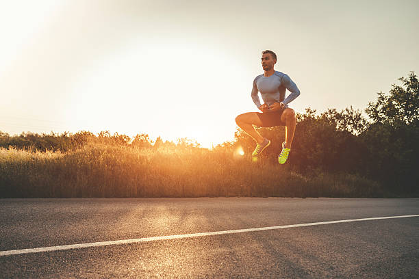 istock Athletic man exercising jumps outdoors 595736600