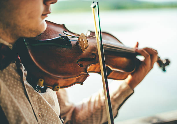 istock Playing violin by the lake 595739242