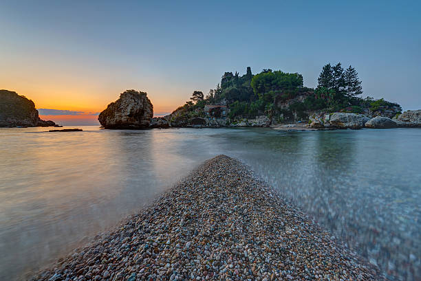 Isola Bella in Sicily at dusk The small Isola Bella in Taormina, Sicily, just before sunrise isola bella taormina stock pictures, royalty-free photos & images
