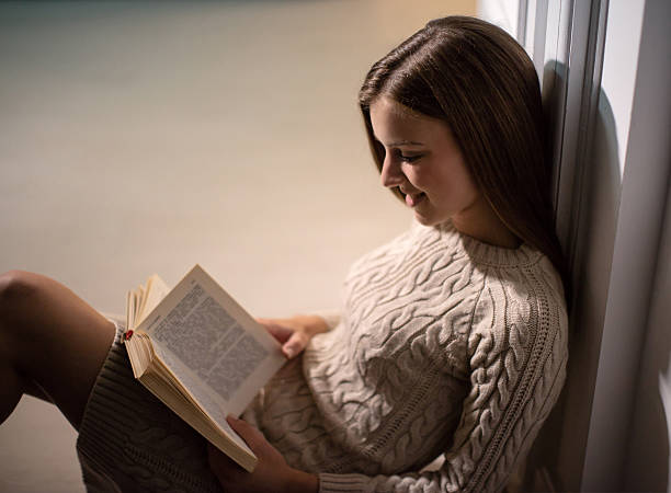 istock Reading a book in living room 595743534