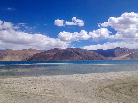 Pangong tso (Lake). It is huge lake in Ladakh, with snow peaks and blue sky in background, it extends from India to Tibet. Leh, Ladakh, Jammu and Kashmir, India