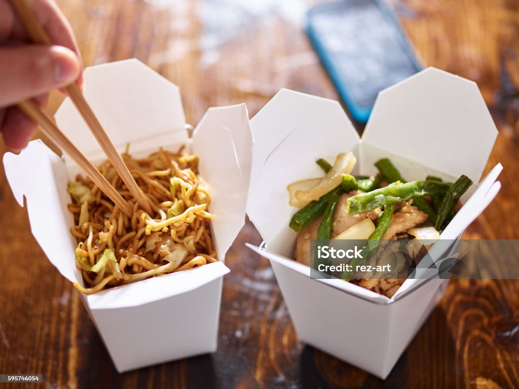 eating lo mein out of chinese take out box eating lo mein out of chinese take out box wih chopsticks Chinese Takeout Stock Photo