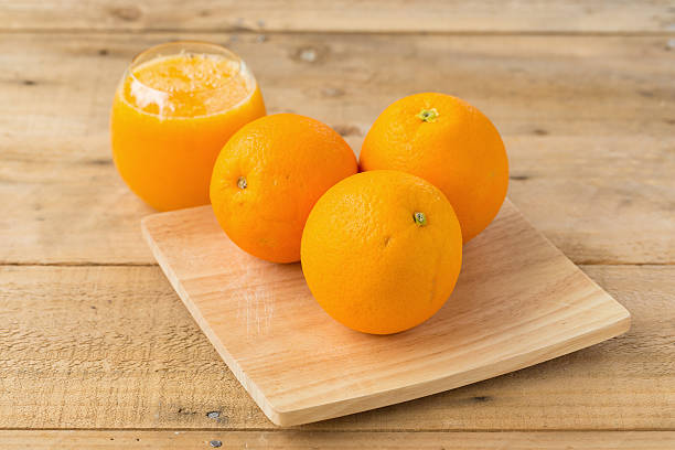 istock Orange juice and slices  on wooden table 595747648