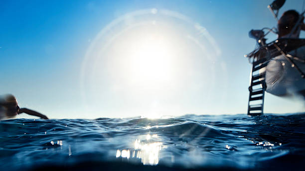 istock Man jumping and diving from a yacht sailboat 595748154