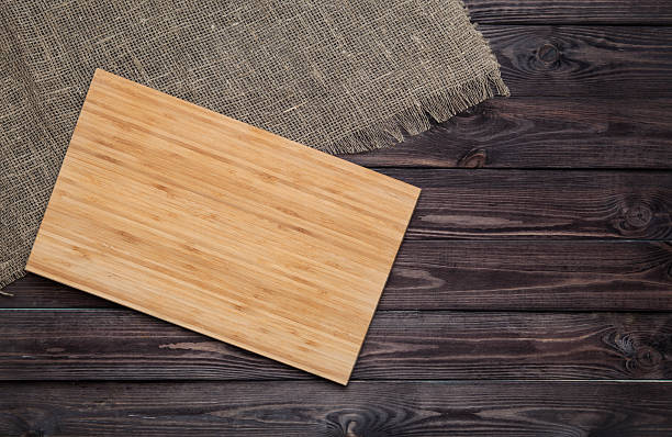 istock Empty cutting board on dark wooden planks food background concept 595749186