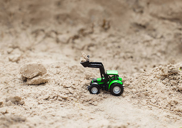 istock toy green tractor on sand career,  equipment 595749556