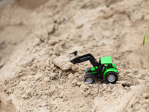 istock toy green tractor on sand career,  equipment 595749638