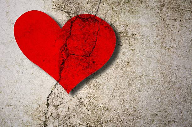 istock Cracked red heart on concrete wall 595749758