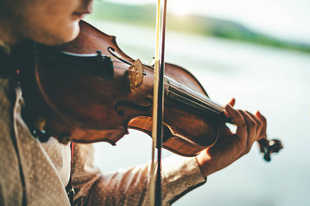istock Playing violin by the lake 595753228