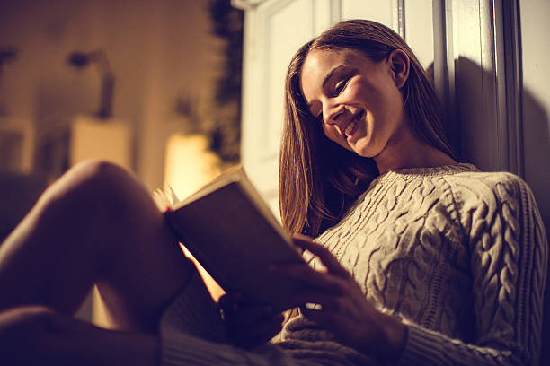 istock Sitting on floor and reading a book in living room 595755574