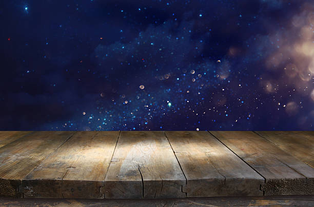 istock wooden table in front of glitter lights background 595756526