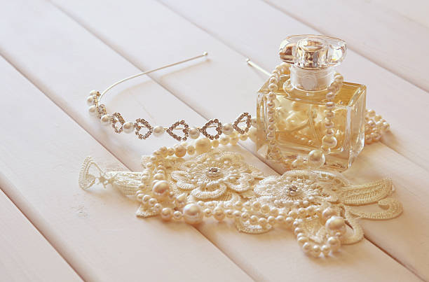 istock White pearls necklace, diamond tiara and perfume bottle 595756702