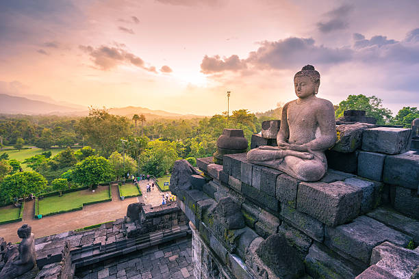 Buddha statue in Borobudur, Buddist Temple in Yogyakarta, Indone Carved stone buddha statue in small stupa around top of Borobudor, world largest buddhist temple in Yogyakarta, Indonesia. java stock pictures, royalty-free photos & images