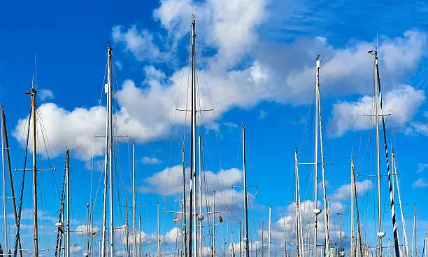 Ship masts against blue cloudy sky. Port of Barcelona, Spain