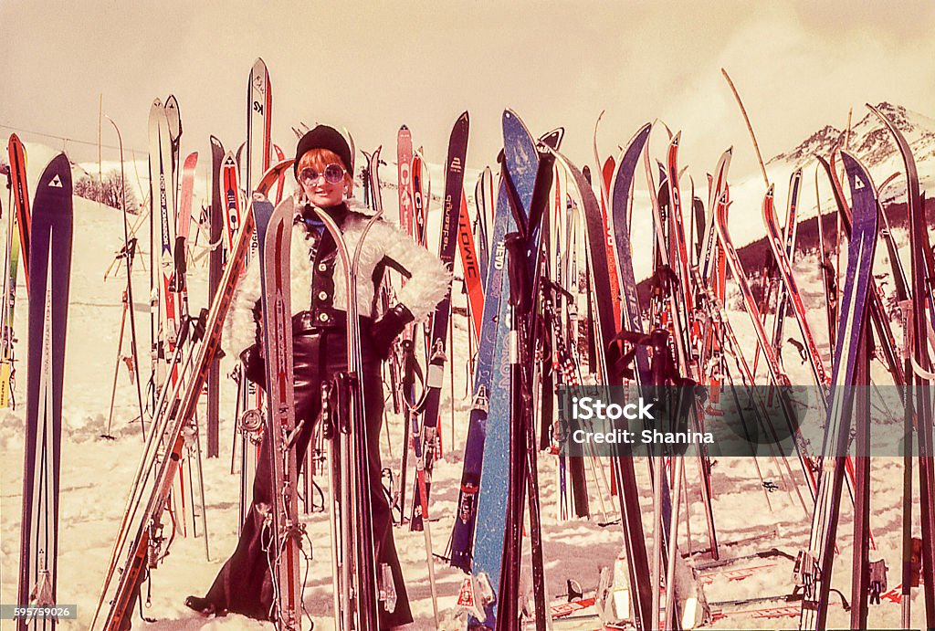 mujer standind rodeado de esquís - Foto de stock de Retro libre de derechos