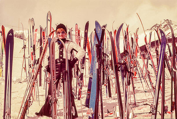 woman standind sorrounded by skis Vintage photo featuring a woman standing surrounded by skis on the snow. skiing photos stock pictures, royalty-free photos & images
