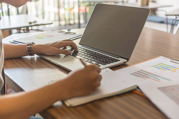 Eine hand suchen Informationen über laptop und einer hand zu schreiben – Foto