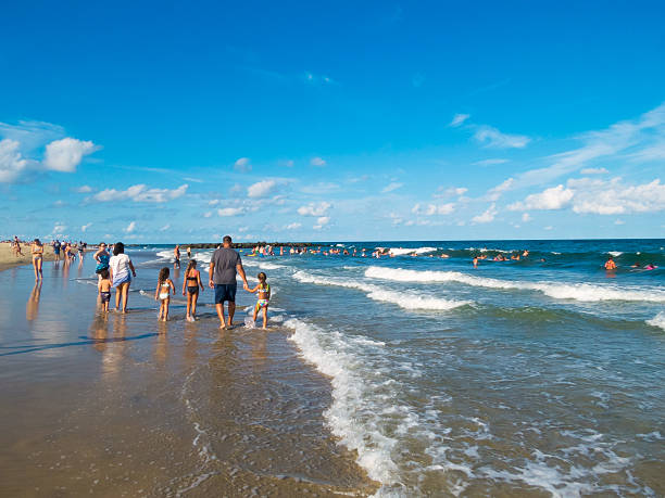 Spring Lake NJ, USA - August 20, 2016: A family walks along the shoreline on a warm Summer day in Spring Lake, along the Jersey shore.