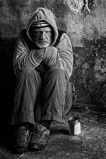 beggar sitting against a wall - vagabundo imagens e fotografias de stock