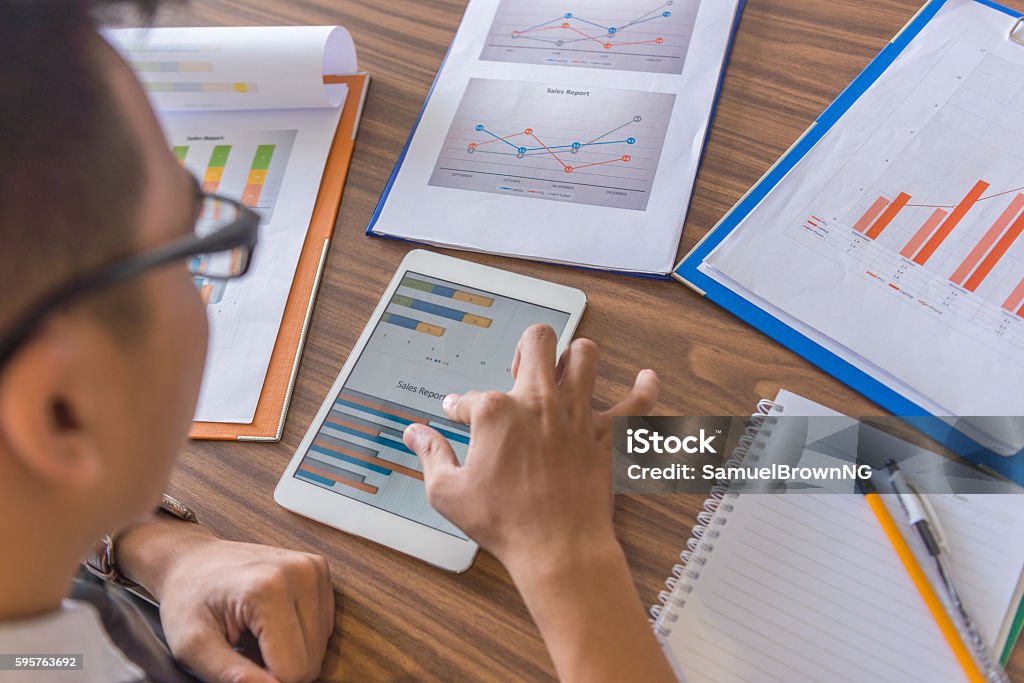 Using Tablet To Show Data While Dealing With Sales Report Stock Photo ...