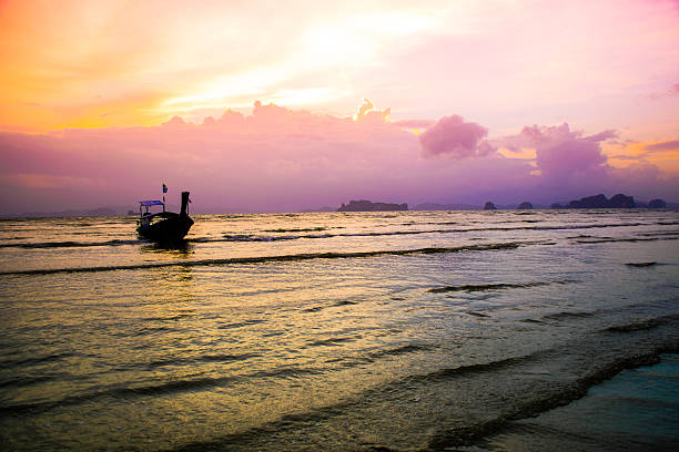 sea at sunset time with a boat - thailand beach nautical vessel phuket province imagens e fotografias de stock