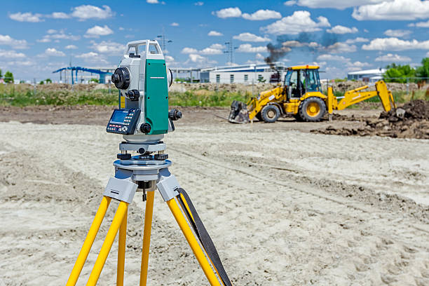 Geodesist device, is working with total station. Surveyor engineer is measuring level on construction site. Surveyors ensure precise measurements before undertaking large construction projects. civil engineering stock pictures, royalty-free photos & images