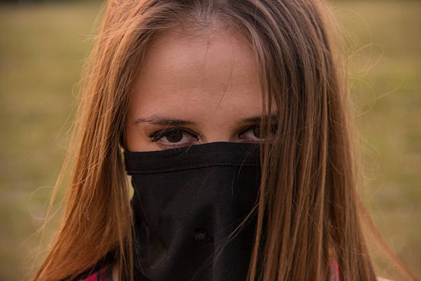 Young girl with scarf on her face