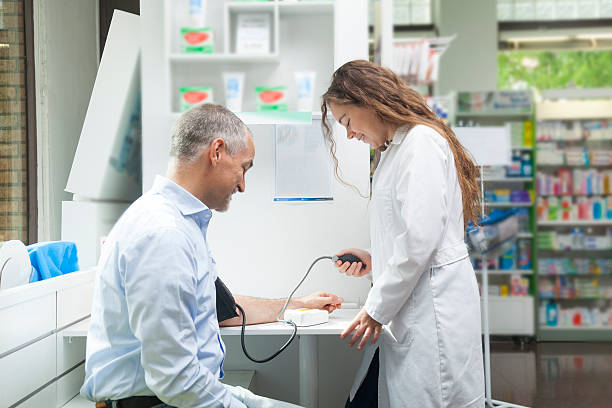 Girl taking blood pressure to mature man stock photo