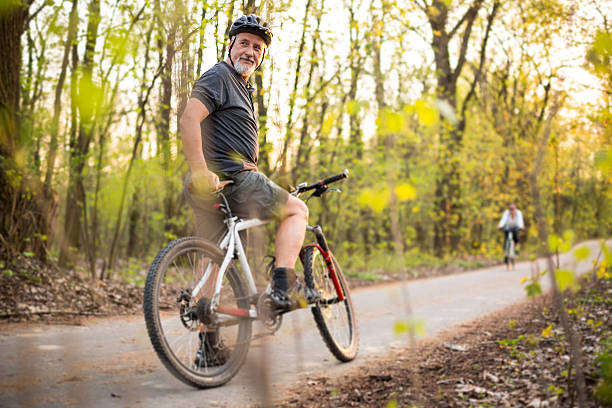 homme senior sur son vélo de montagne en plein air - cycling senior adult sports helmet men photos et images de collection