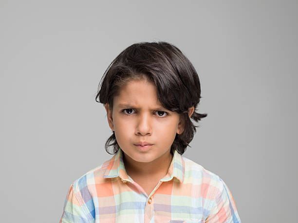 istock Portrait of angry young boy looking at camera 595768360