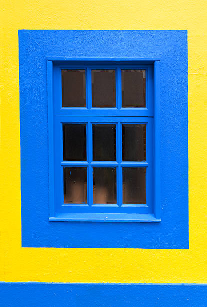 istock Blue wooden window and yellow wall 595768722