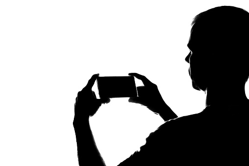 Young man with the phone in his hands - silhouette