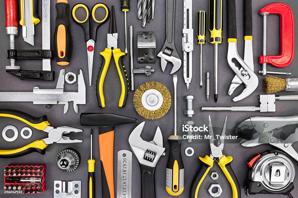 set of hand various work tools on grey background set of hand various work tools on grey background top view including different kinds of wrenches, pliers, clamps, calipers and other Work Tool Stock Photo