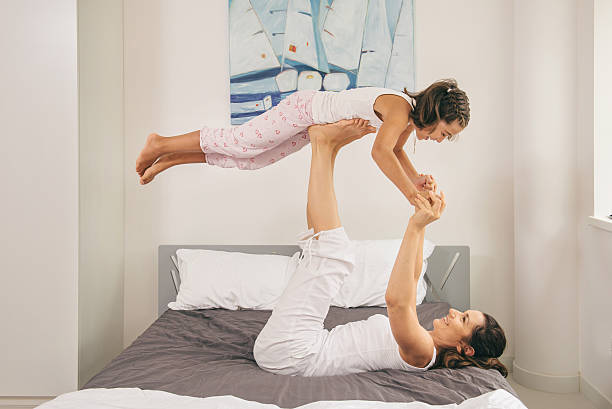 istock Mother with daughter doing yoga exercise in bed 596048470