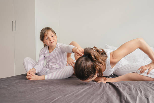 istock Mother with daughter doing yoga exercise in bed 596049178