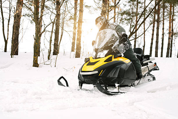 mann auf schneemobil. wintersport. - schneemobilfahren stock-fotos und bilder