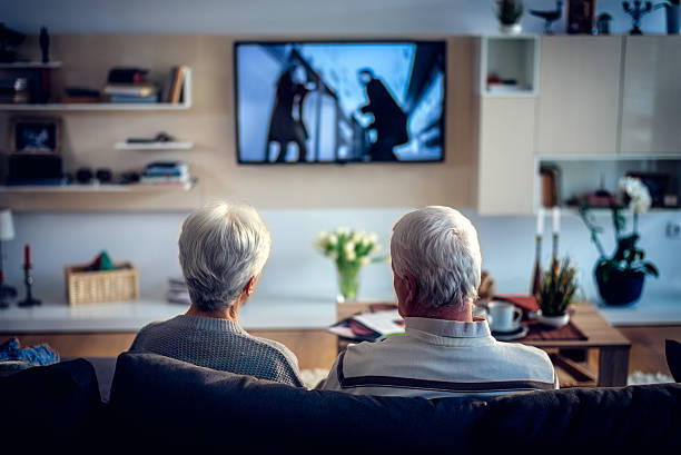 istock Rear view of unrecognizable senior couple looking television 596050720