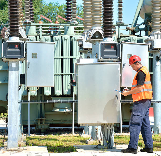 ingegnere con red hardhat work in power plant, near transformer. - inspector built structure engineer clipboard foto e immagini stock