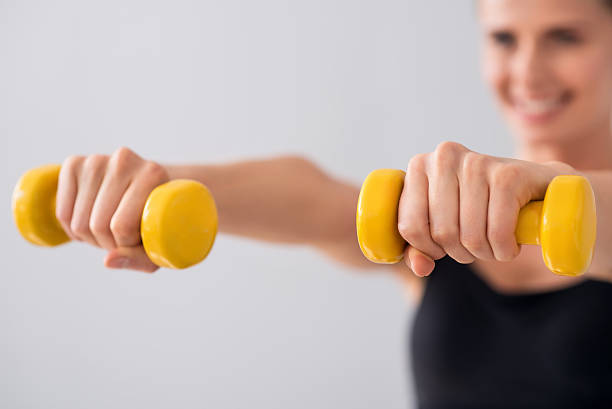 istock Cute young woman with dumbbells 596054546